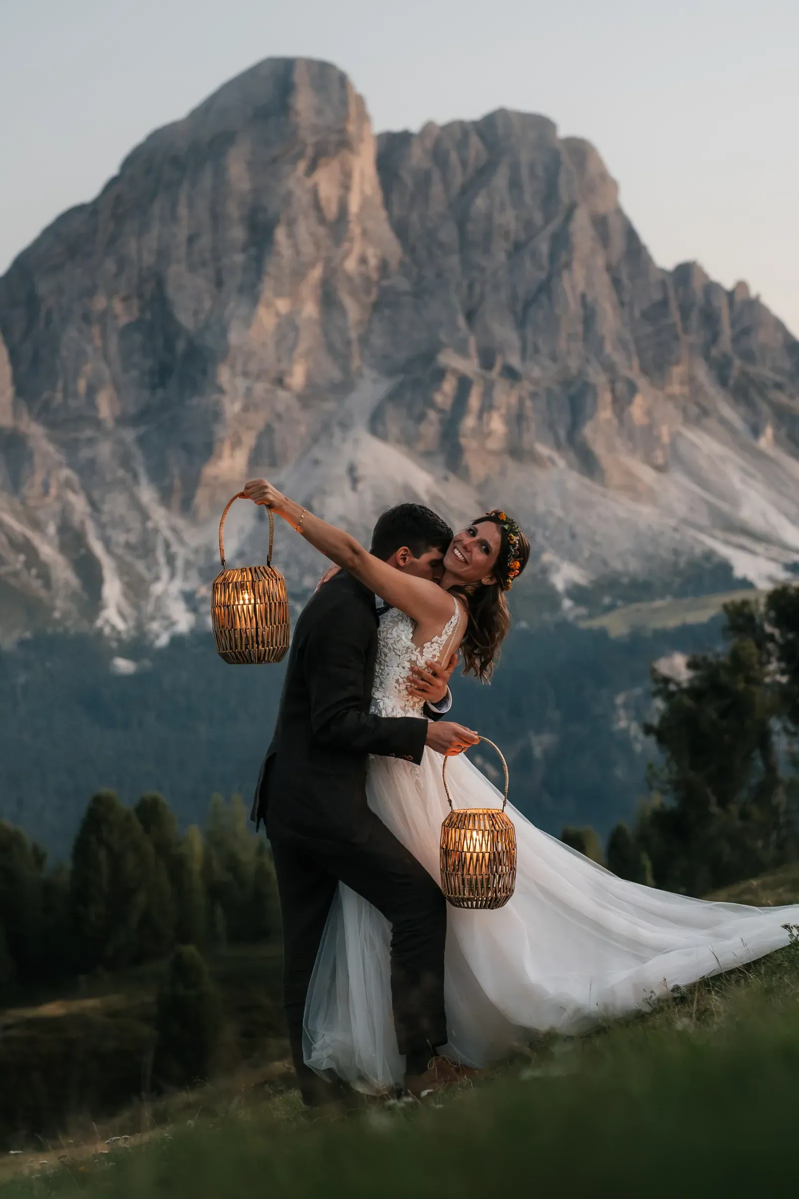 Brautpaar küsst sich und hält Laternen in die Höhe, Abendlicht in den Dolomiten