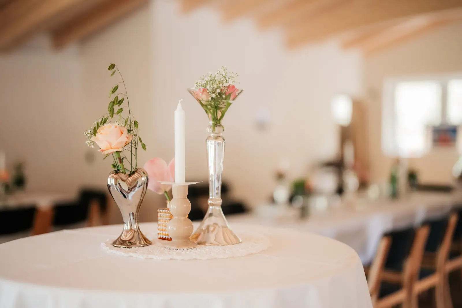 Tischdekoration mit Blumen und Kerzen im Festsaal