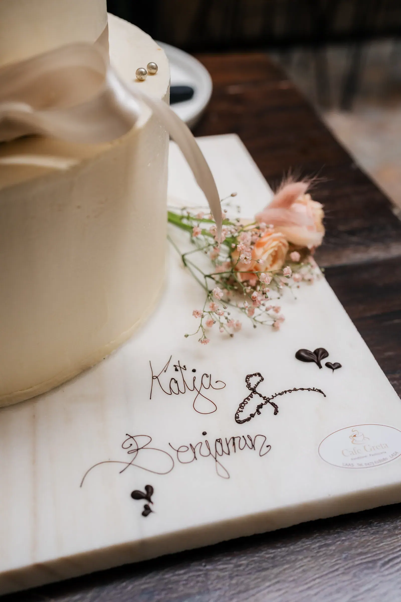Hochzeitstorte mit den Namen des Brautpaars auf dem Tortenbrett