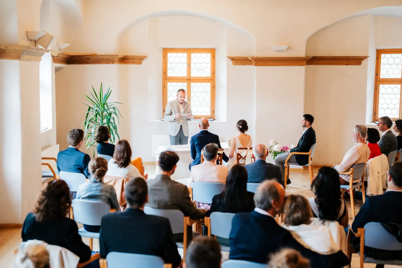 Gäste bei der Trauung im hellen Schlosssaal