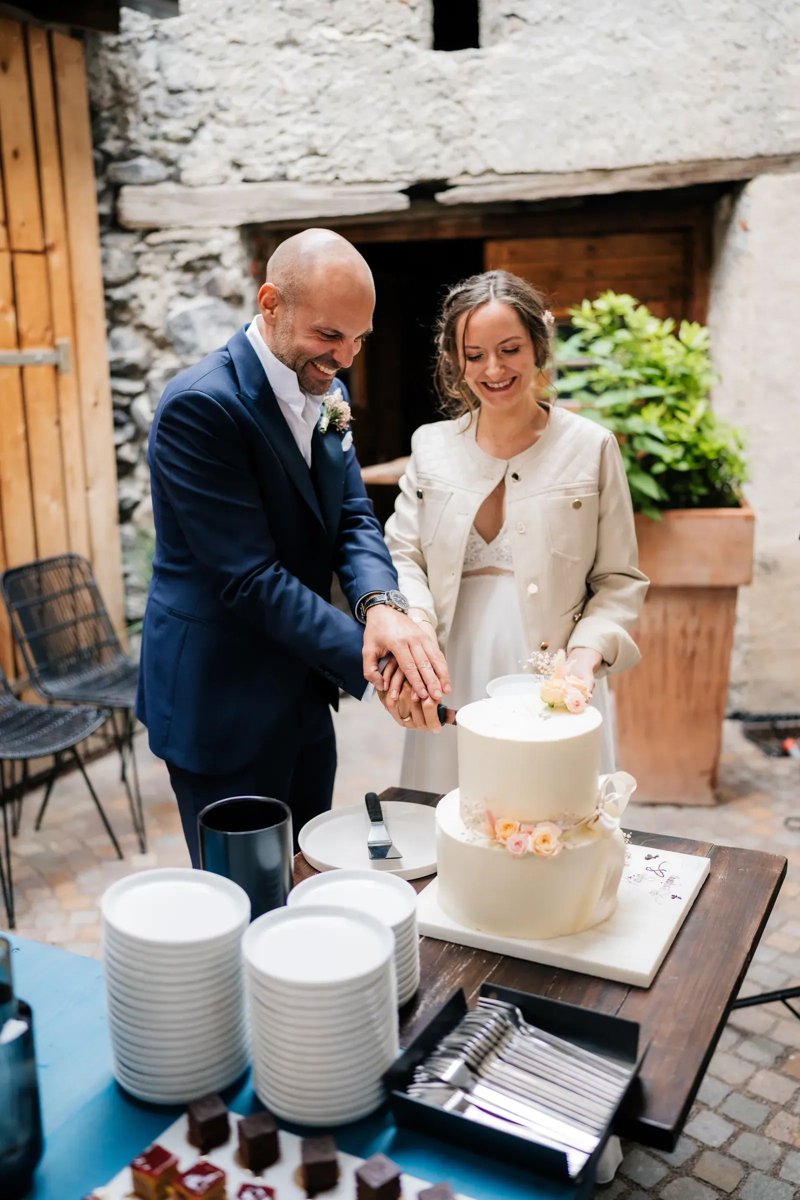 Brautpaar schneidet lachend die Hochzeitstorte an, Schlosshochzeit in Südtirol